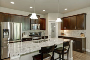 large kitchen island with granite countertops and backsplash